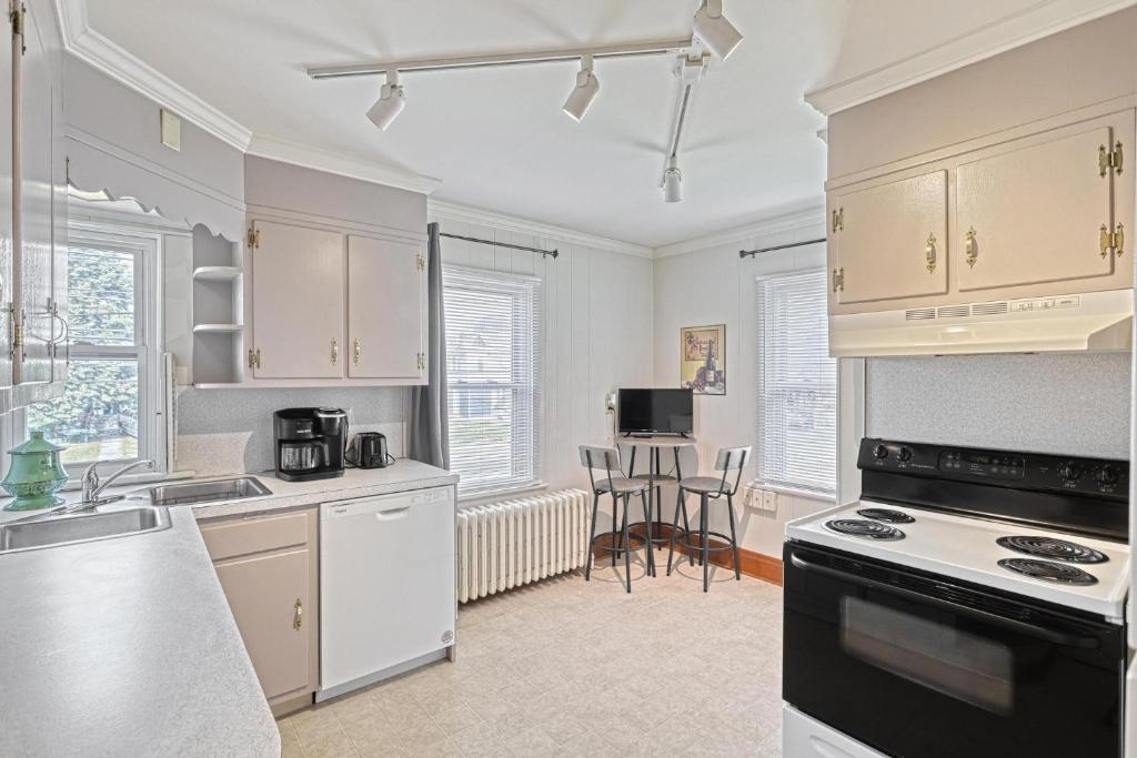 eine Küche mit weißen Schränken und einem Herd mit Backofen in der Unterkunft Suites On Chocolate - The Hershey House in Hershey