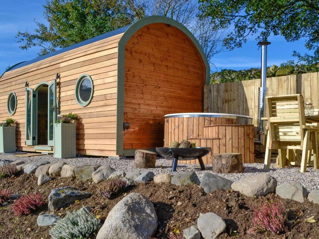 een kleine schuur met een bank in een tuin bij Heather - Uk34841 in Straiton