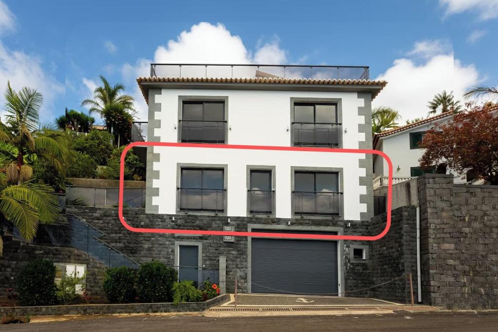 un edificio bianco con una linea rossa sopra di Skyline Villas RC a Calheta