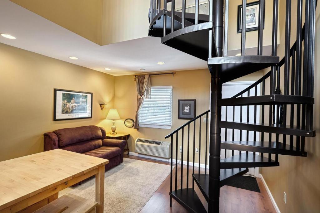 eine Wendeltreppe in einem Wohnzimmer mit einem Sofa in der Unterkunft Suites On Chocolate - The Theater in Hershey