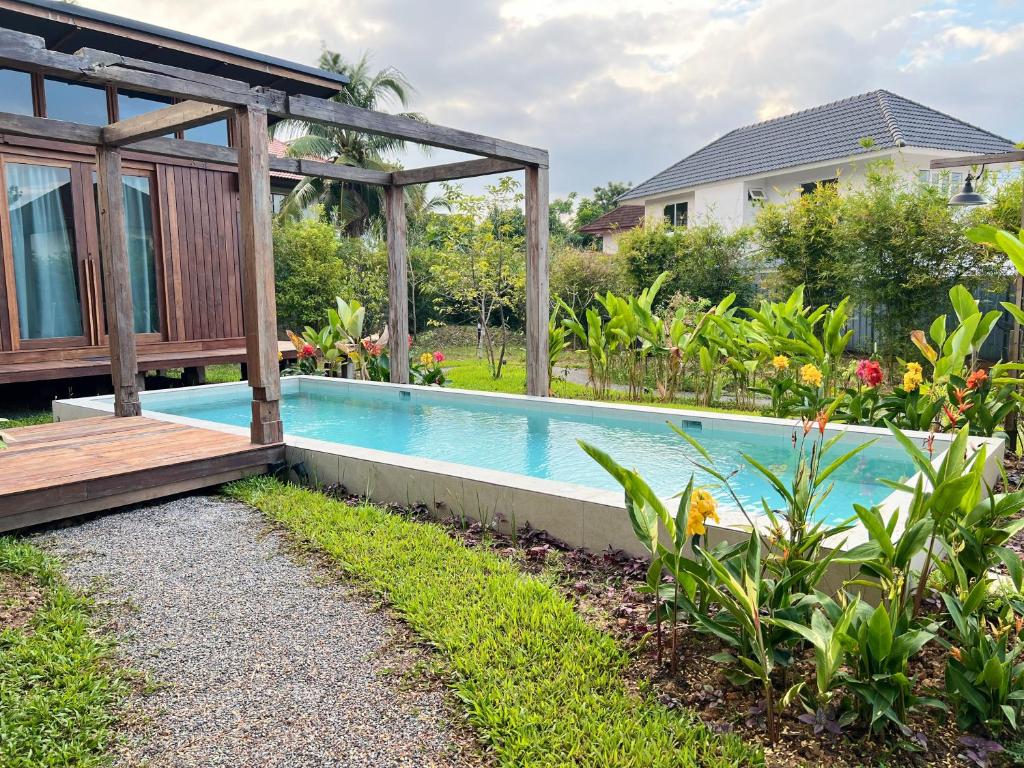 una piscina in un cortile con una casa di San Kue Village - Chiang Mai Pool Villas a Chiang Mai