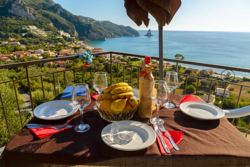 a table with a basket of food and wine glasses at Sunny views studios in Agios Gordios