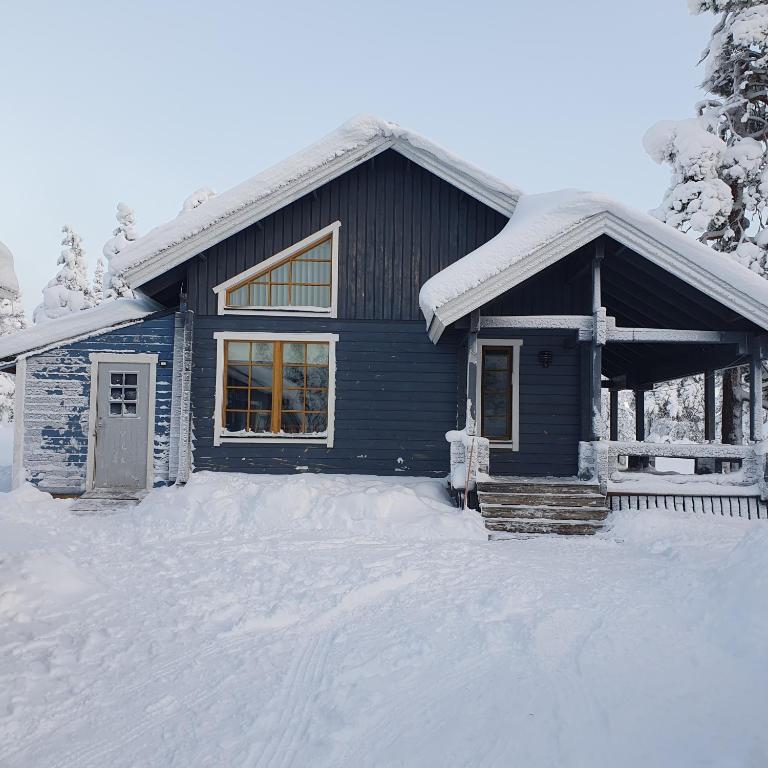 a blue house with snow on the ground at Yläkolo - A functional cottage in a good location in Saariselka