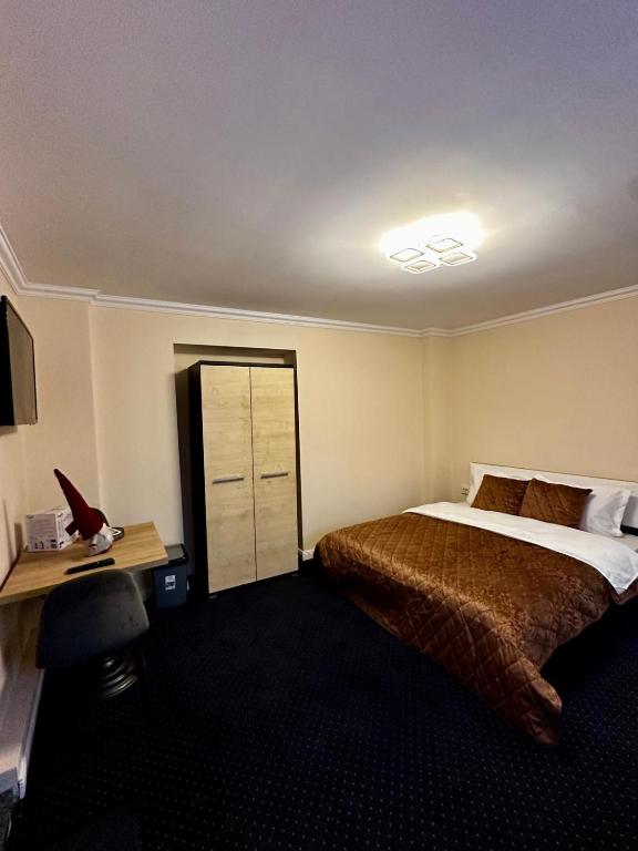 a hotel room with a bed and a desk at Udroiu Residence 2 in Craiova
