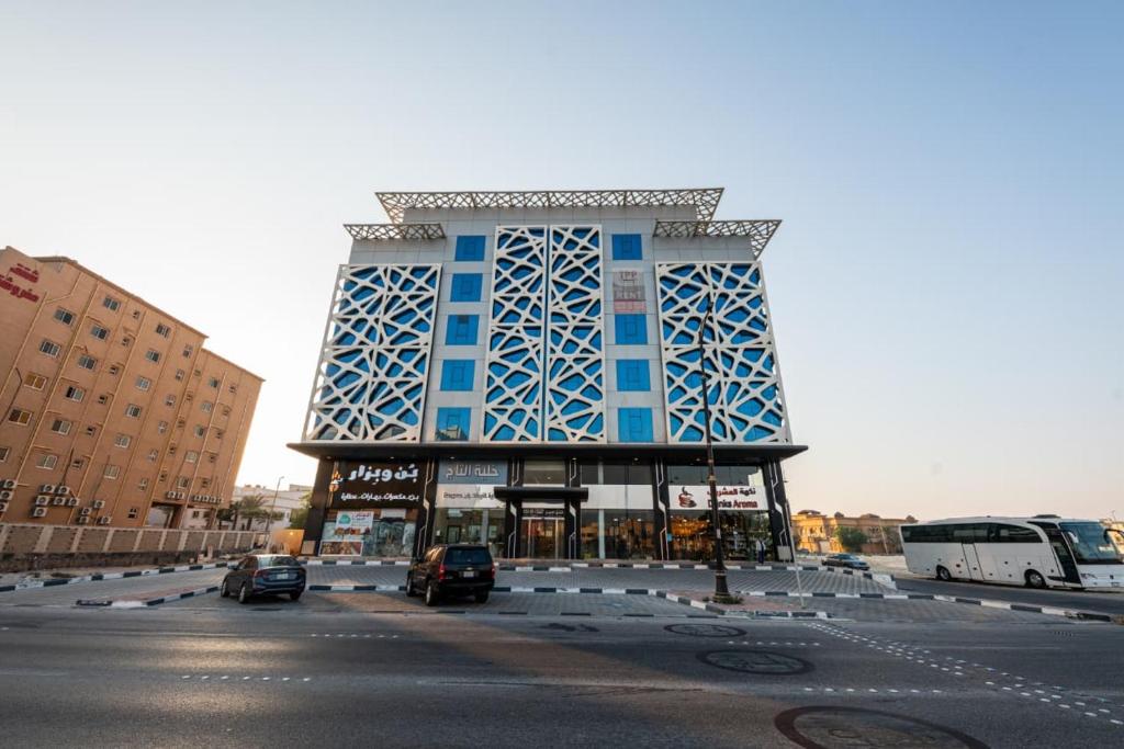 un bâtiment bleu avec des voitures garées dans un parking dans l'établissement إطلالة الشاطئ, à Dammam