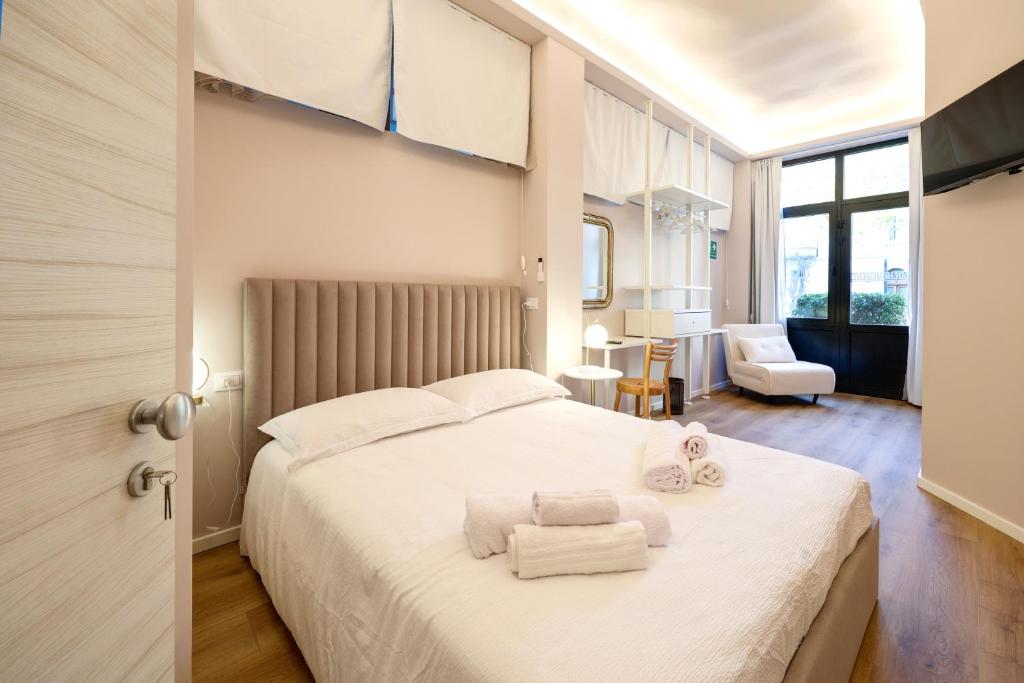 une chambre avec un grand lit blanc avec des serviettes dessus dans l'établissement Residence Concordia, à Gorizia