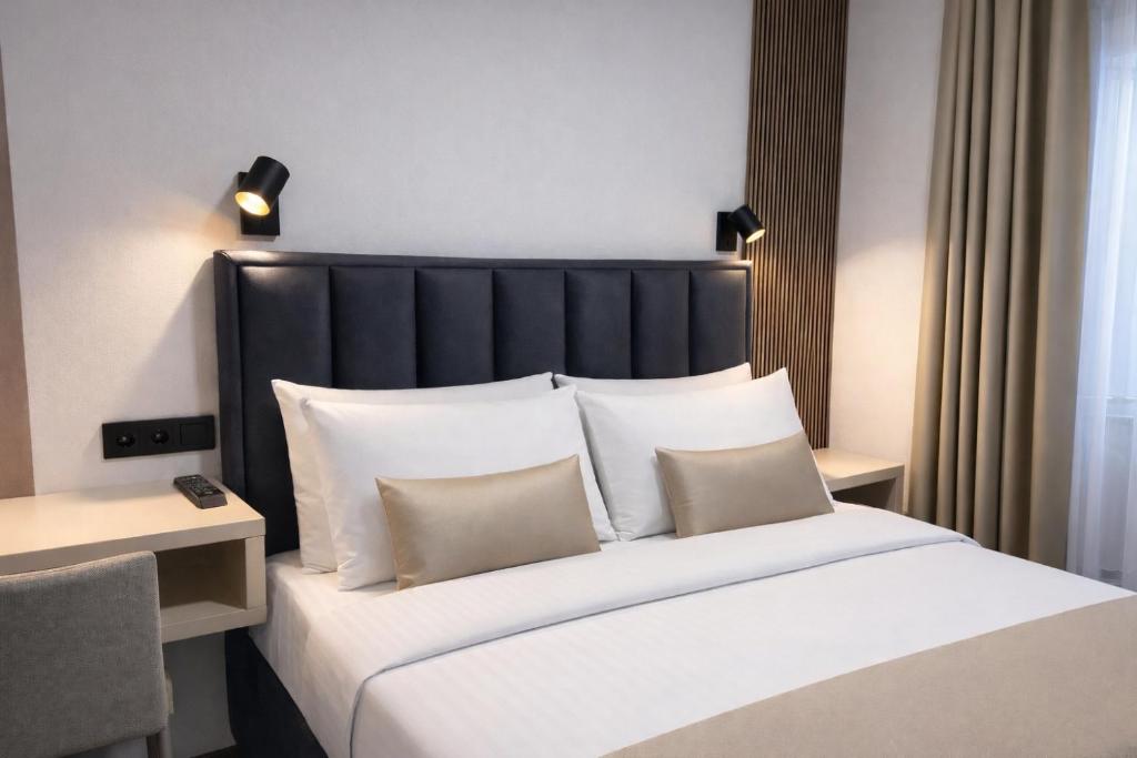 萨拉热窝Hotel Villa Harmony - Free Parking的卧室里有一张大床，配有白色枕头