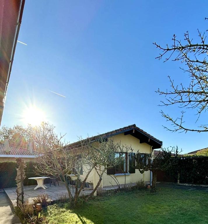 a house with the sun shining behind it at Le Tuc de Rose in Mimizan