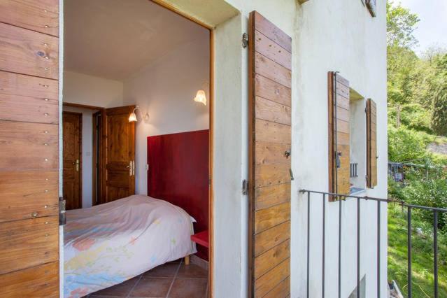 ein kleines Schlafzimmer mit Bett und Balkon in der Unterkunft Gîtes la fontaine corse vue panoramique in Loreto-di-Casinca
