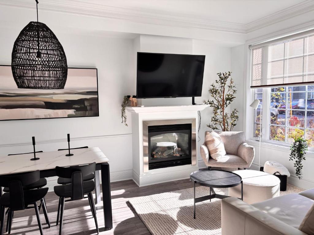 ein Wohnzimmer mit einem Kamin und einem TV an der Wand in der Unterkunft MC'S nB in Saint-Sauveur-des-Monts