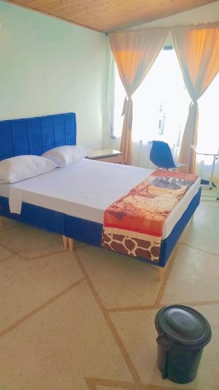 a bedroom with a bed with a blue headboard at Colibri Hostel in Armenia