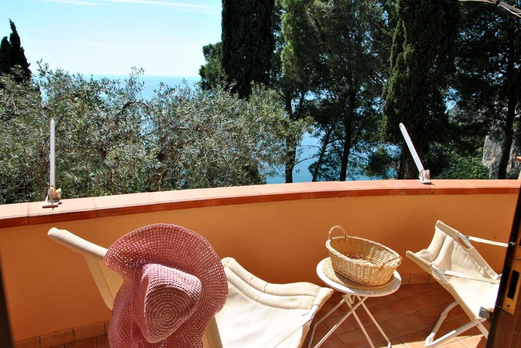 a balcony with chairs and a table and a basket at Casa Simon tra mare e natura in Sperlonga