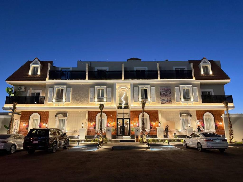 ein großes Gebäude, vor dem Autos parken in der Unterkunft منوة المساكن in Quai