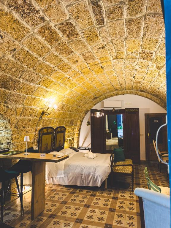 een slaapkamer met een bed en een tafel in een kamer bij Corte Lirice Paradiso in Gioia del Colle