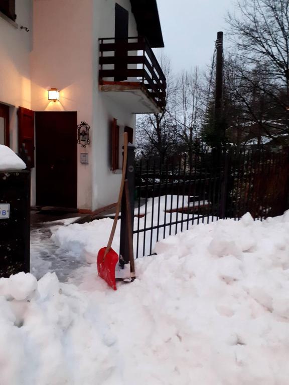 een sneeuwschep in een hoop sneeuw voor een huis bij Chalet Relax&Salute in Pianosinatico