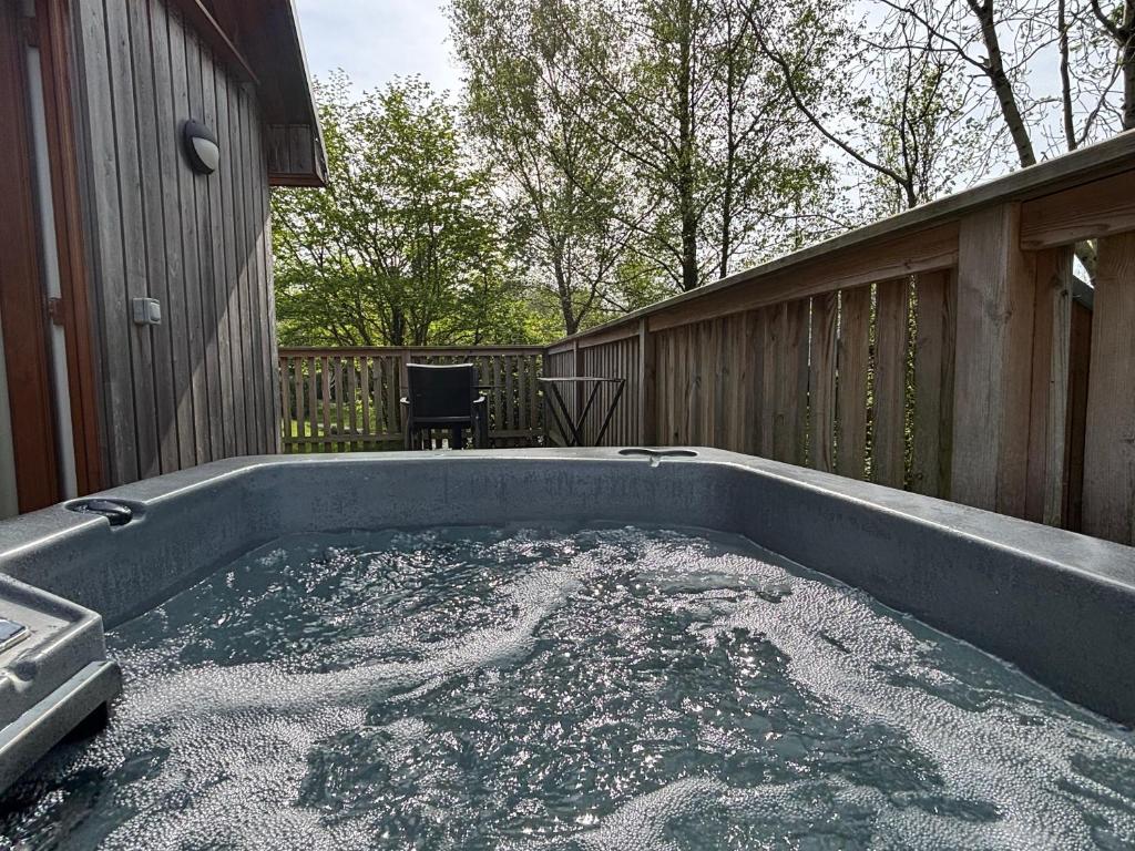 un jacuzzi en el patio trasero de una casa en Kestrel Lodge 2 with Hot Tub, en Newton Stewart