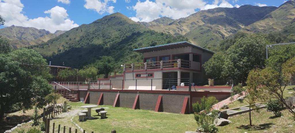 a building with mountains in the background at Crepúsculo Serrano in Merlo