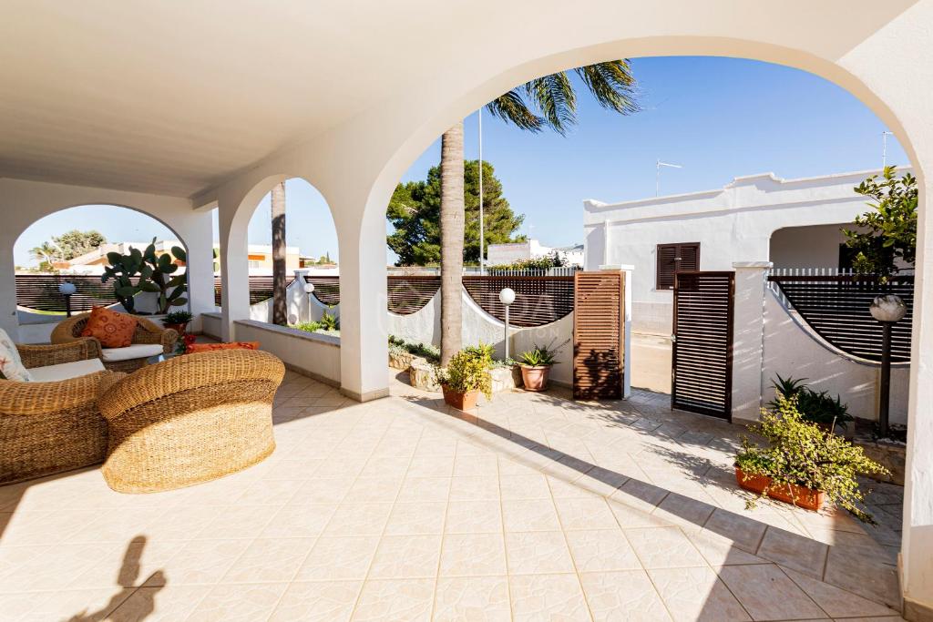 een patio met tuinmeubilair en een boog bij Giorni Salentini in Torre Lapillo