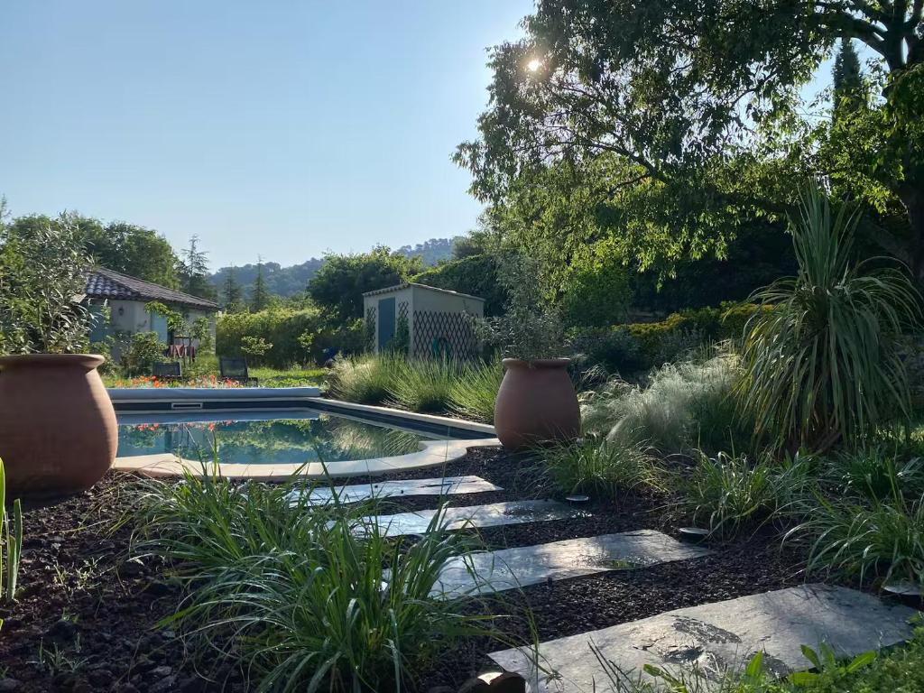 a swimming pool in a garden with plants at Studio tout confort dans la campagne aixoise in Le Puy-Sainte-Réparade