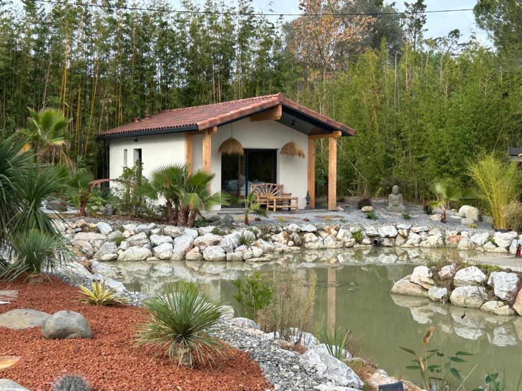 ein kleines Haus mit einem Teich im Garten in der Unterkunft Domaine Coul'eau in Eaunes