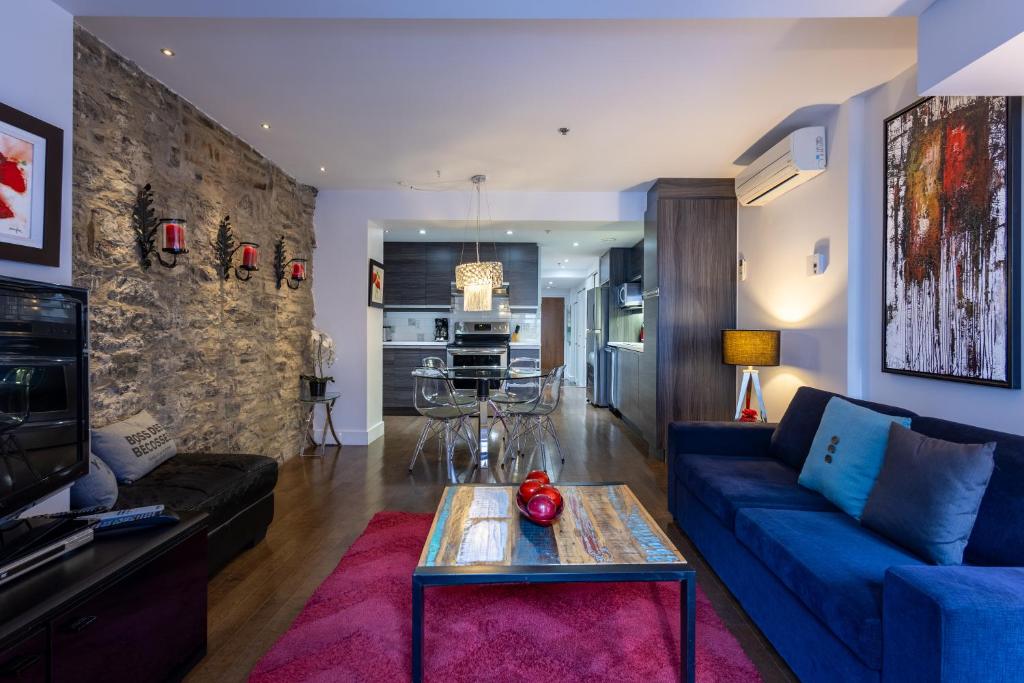 ein Wohnzimmer mit einem blauen Sofa und einem Tisch in der Unterkunft Les Immeubles Charlevoix - Le 1166 in Québec