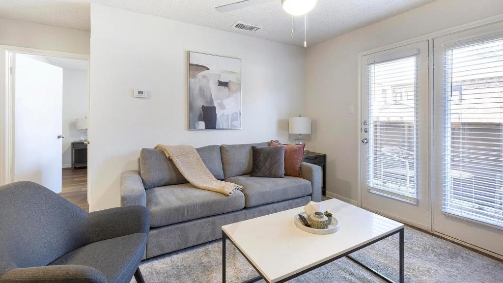 ein Wohnzimmer mit Sofa und Tisch in der Unterkunft Landing Apartments - Denton in Denton