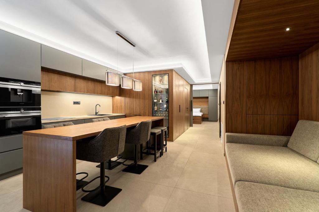 eine Küche mit Holzschränken und eine Bar mit Stühlen in der Unterkunft LUXURY SUITE Boží Dar in Boží Dar