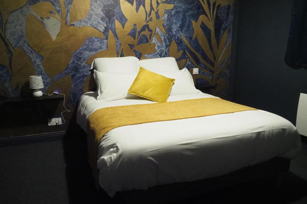 een slaapkamer met een groot bed met een geel kussen bij Résidence Saint Pôl in Nogent-le-Rotrou