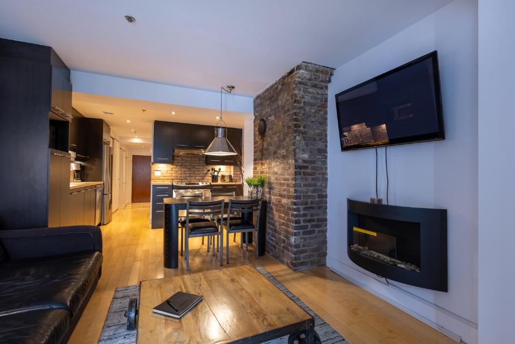 a living room with a fireplace and a dining room at Les Immeubles Charlevoix - Le 1168 in Quebec City