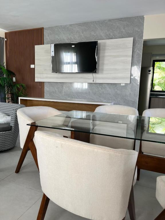 a dining room with a glass table and white chairs at Villa Medrano 