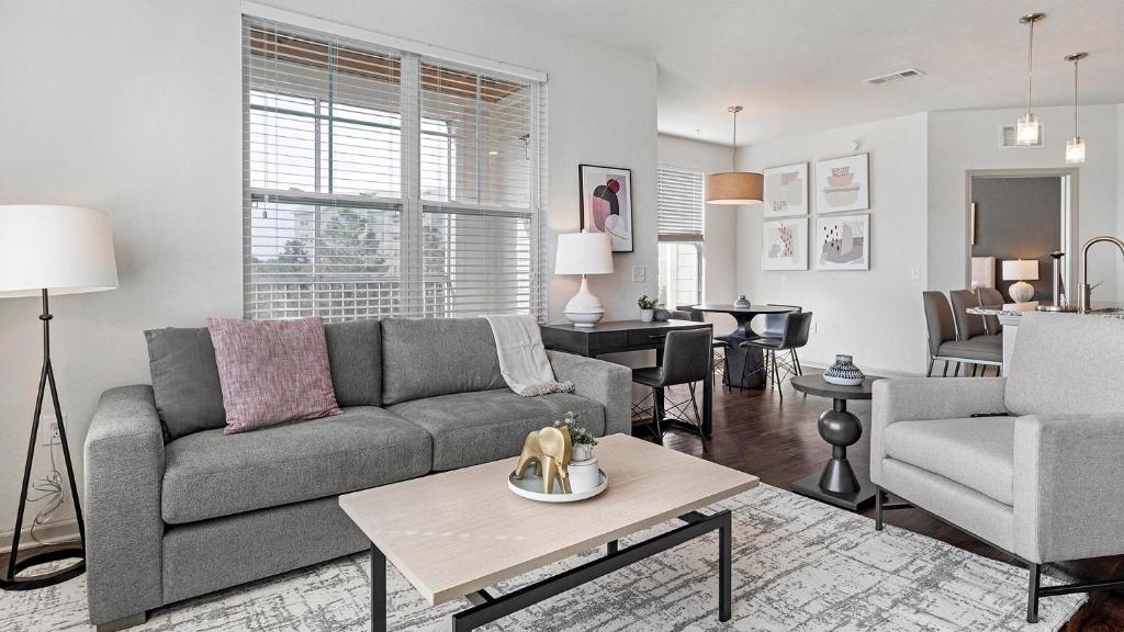 een woonkamer met een bank en een tafel bij Landing Apartments - Longmont in Firestone