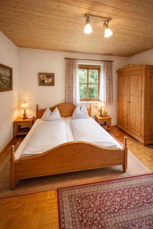 a large wooden bed in a room with a window at Ferienwohnungen an der RupertusTherme in Bad Reichenhall