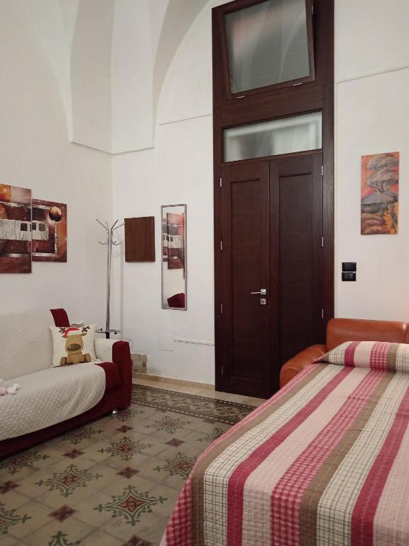 a bedroom with two beds and a brown door at B&B Casa dolce casa in Cutrofiano