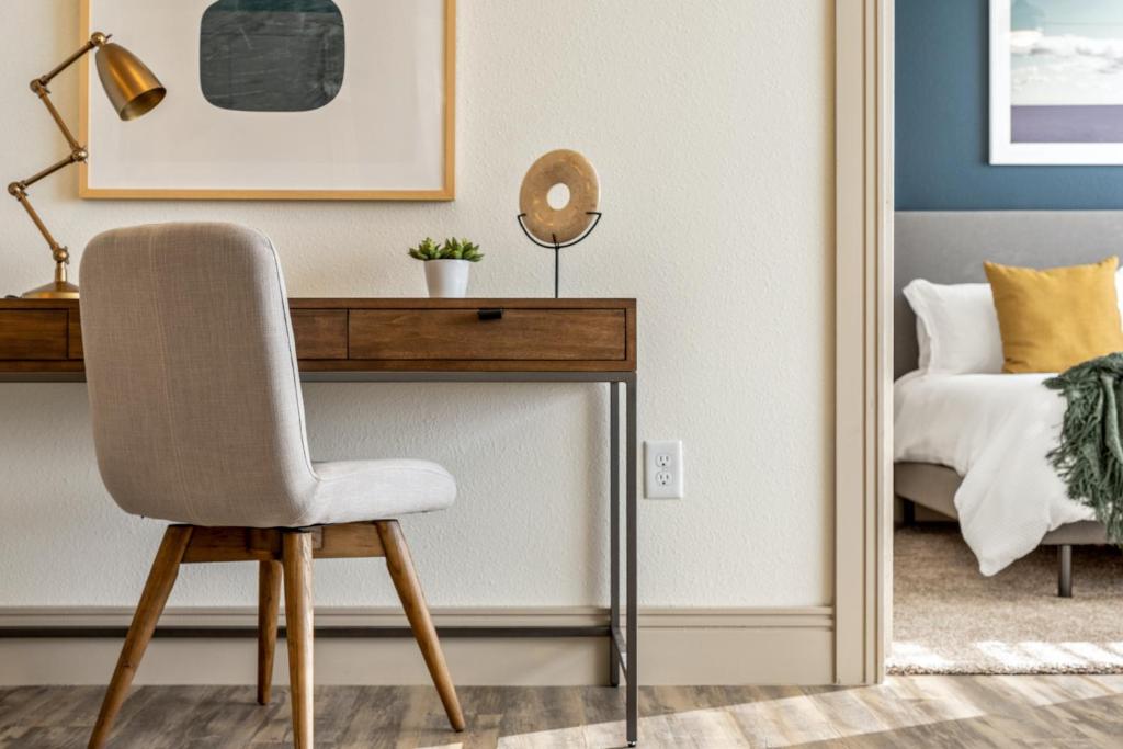 un bureau avec une chaise à côté d'un lit dans l'établissement Landing Apartments - Spartanburg, à Spartanburg