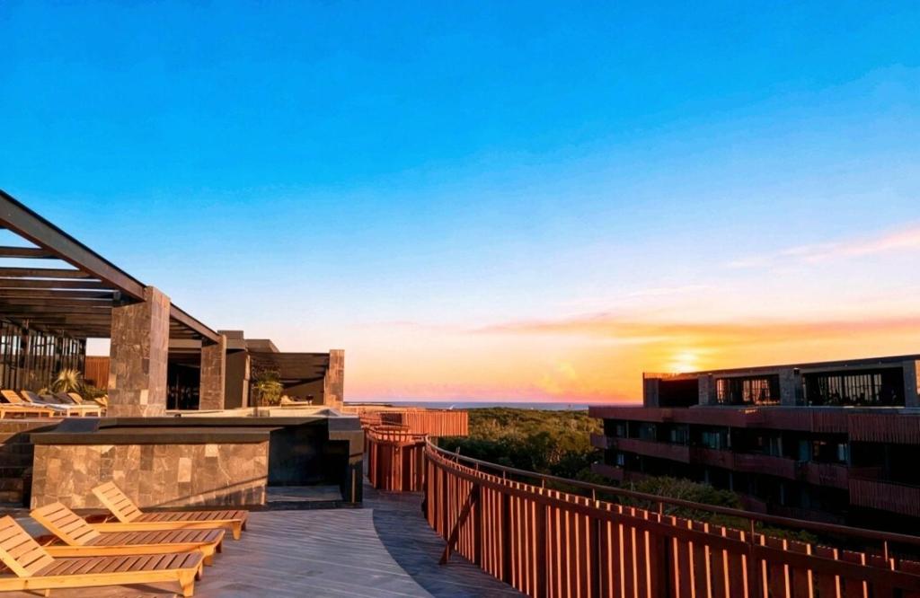 een resort met uitzicht op de oceaan bij zonsondergang bij The Empire Amira in Tulum