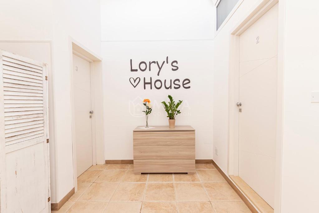 a hallway with a dresser and a house sign on the wall at LORY'S HOUSE in Porto Cesareo