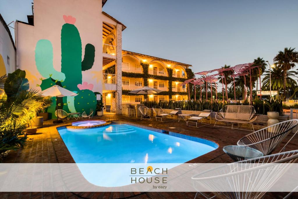 エンセナダにあるBeach House by ULIVの建物の前にプールがあるホテル