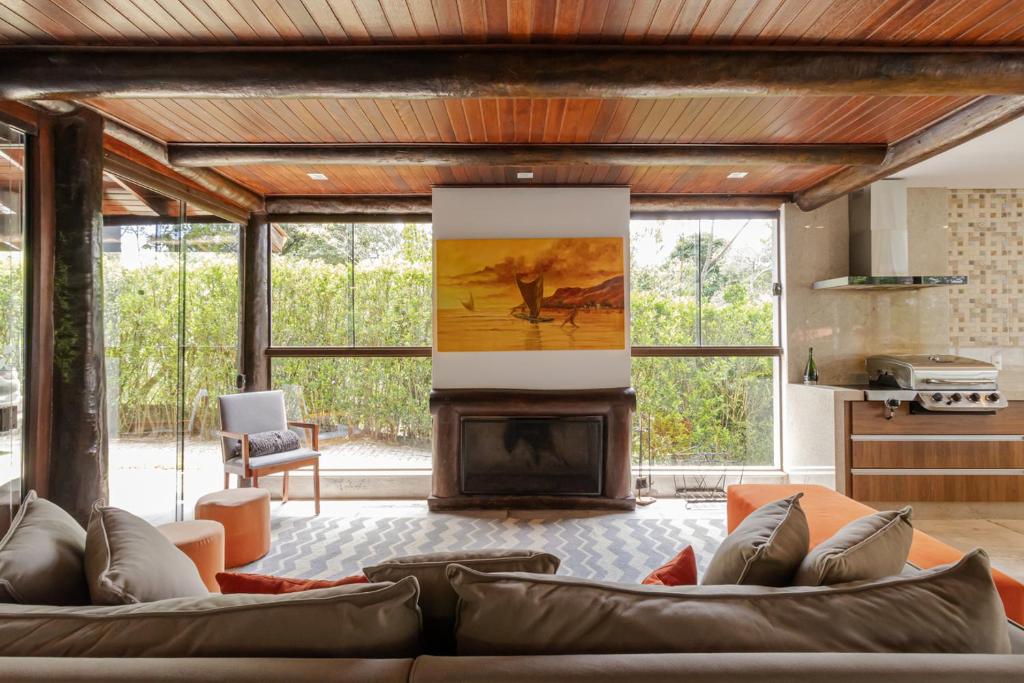 un soggiorno con divano e camino di Casa de Campo Alto Padrao com Piscina e Jacuzzi a Pirituba