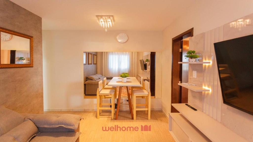 Una pequeña sala de estar con una mesa y un sofá. en Apartamento em Londrina no Centro da cidade, en Londrina