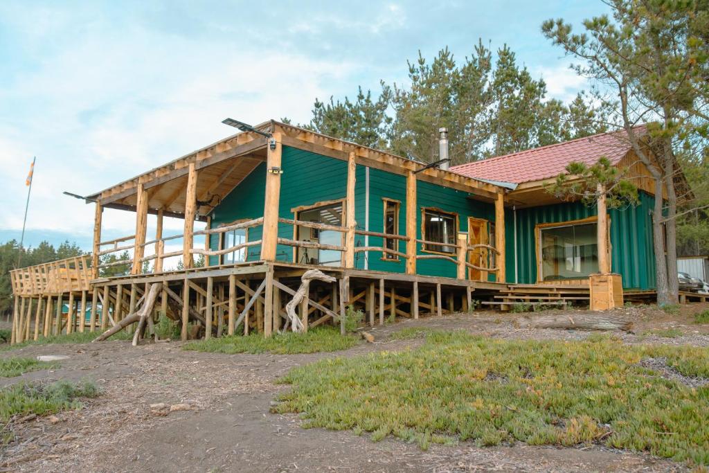 a large green house with a large deck at Cabañas Isla del Mar in Constitución