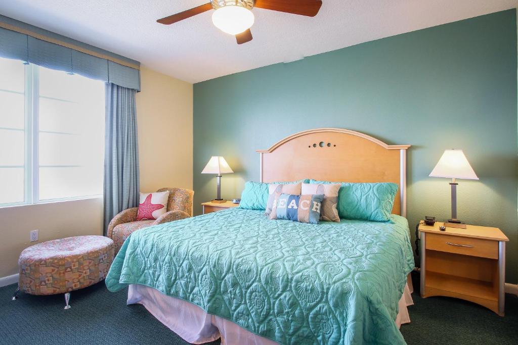 een slaapkamer met een groot bed en een stoel bij Daytona Ocean Walk 2424A in Seabreeze