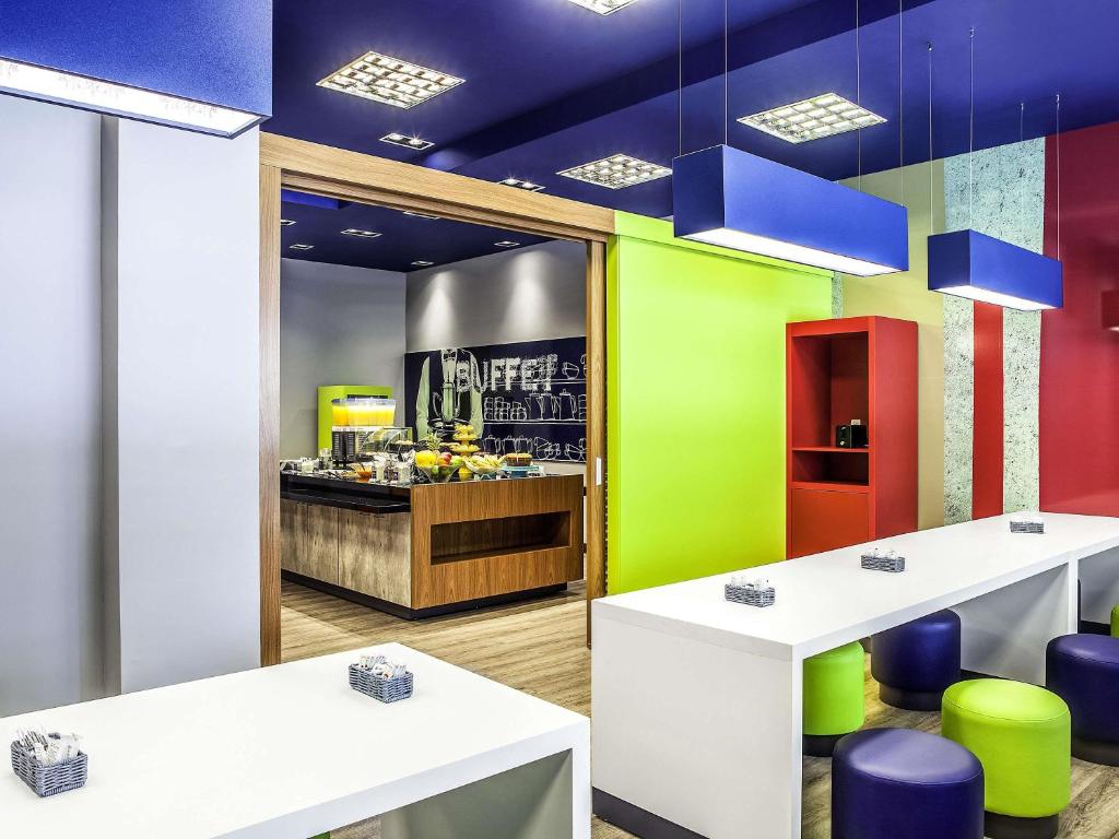 a restaurant with colorful walls and tables and chairs at ibis budget Belo Horizonte Minascentro in Belo Horizonte