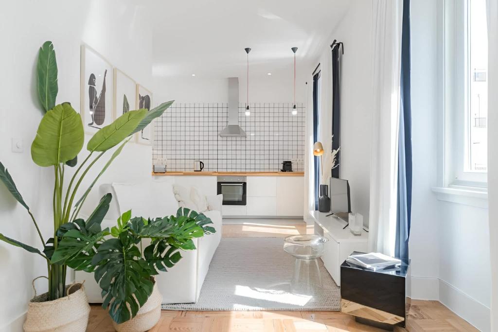 a living room with white walls and plants in it at Charming Lisbon 2BR Apartment with Balcony in Lisbon