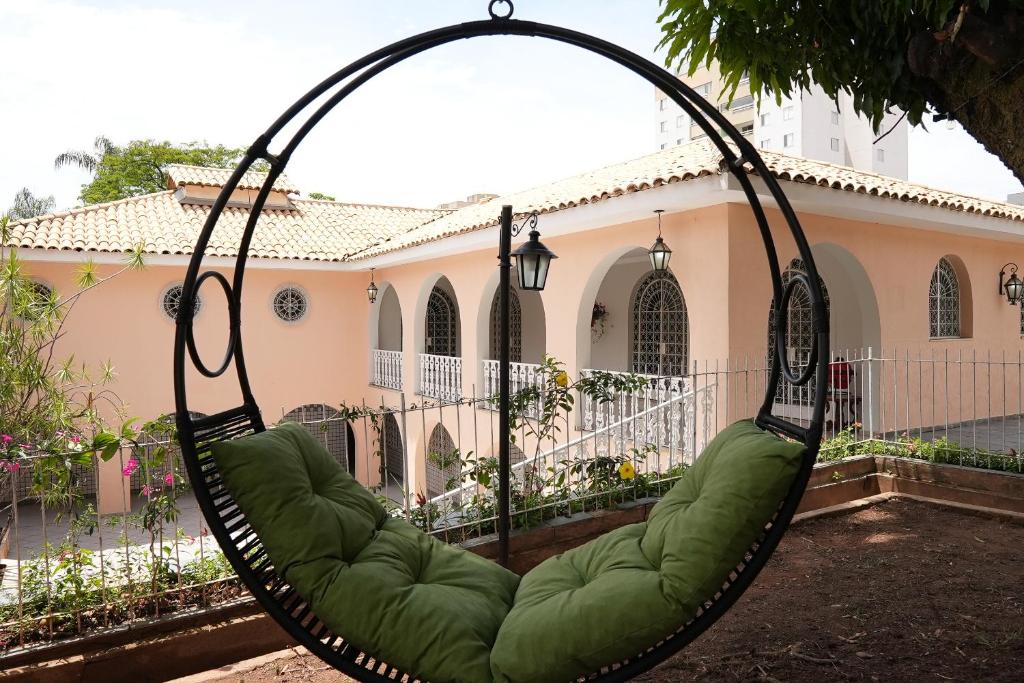 a green swing in front of a house at Casarão José Morada in Belo Horizonte
