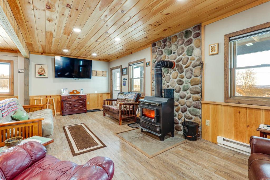 un soggiorno con camino e parete in pietra di Panoramic Upstate Views Tranquil Home on 70 Acres a Prattsburg