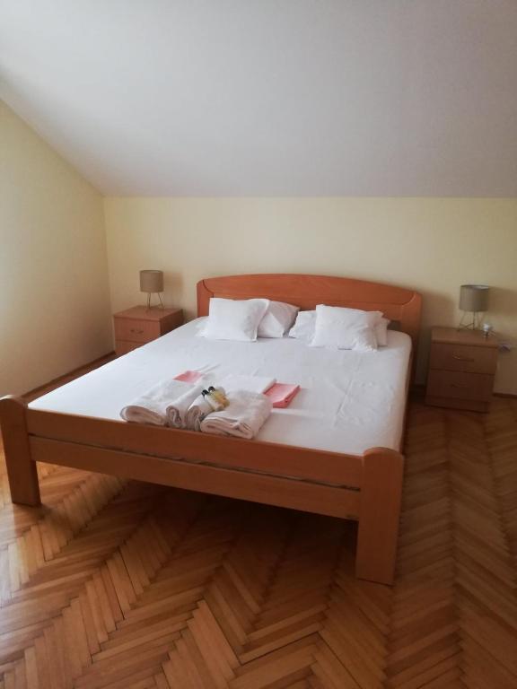 a bedroom with a bed with two towels on it at Apartmani Brkan in Donja Lastva