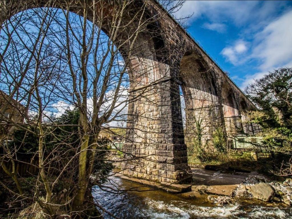 een oude stenen brug over een rivier met bomen bij Labernum Cottage, Ingleton, Yorkshire Dales National Park, Famous Three Peaks, Near The Lake District, Pets Are Welcome in Ingleton 