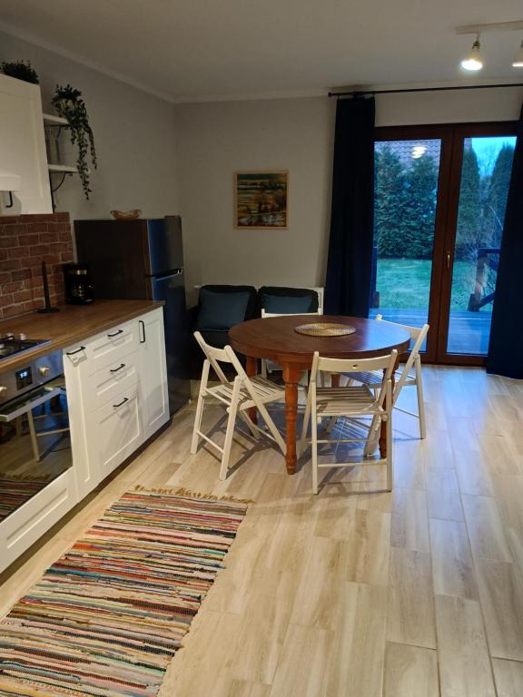 une cuisine et une salle à manger avec une table et des chaises dans l'établissement Mazurska Apartamenty, à Rydzewo