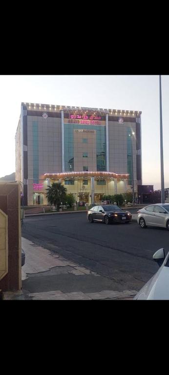 a large building with cars parked in front of it at فندق جراند روز in Najran