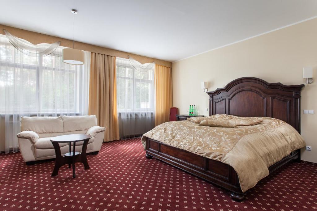 a bedroom with a bed and a couch and a chair at Mineraliniai Apartamentai in Druskininkai